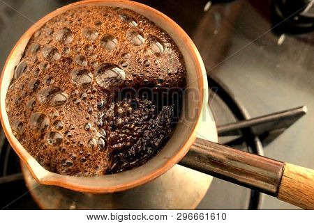 Barista Preparing Hot Tasty Drink From Copper Turk, Boils Water For Coffee On Small Fire In Cezve. C