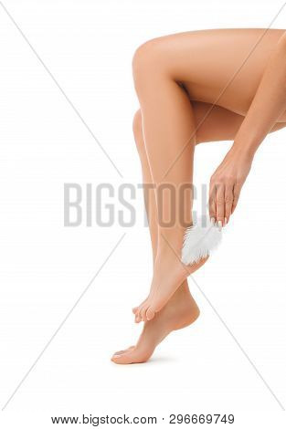 Woman Touching With Feather To Her Smooth Foot. Spa And Foot Care Isolated On White