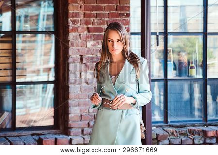 Beautiful Young Blonde Girl With Long Hair In A Flower Dress, A Mint Jacket, A Wide Belt At The Wais