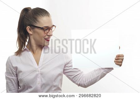 Young Woman In Pink Blouse Long Hair In Tail In Eyeglasses Happy Pointing With Finger At White Banne