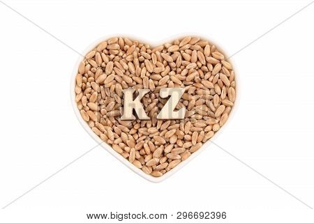 Wheat Grains Lie In A White Plate In The Shape Of A Heart. Kz Of Wooden Letters On The Grain. The Co
