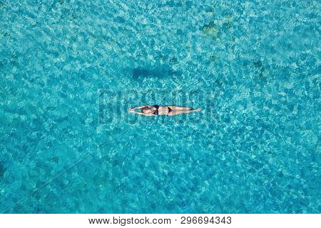 Aerial View Of A Girl On Ocean On Bali, Indonesia. Vacation And Adventure. Turquoise Water. Top View