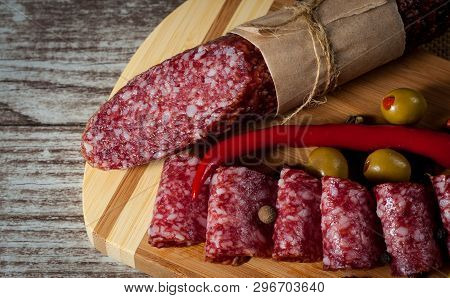 Italian Salami With Olives And Spices On Wooden Background
