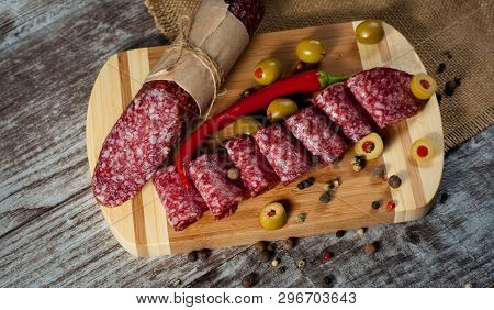 Italian Salami With Olives And Spices On Wooden Background