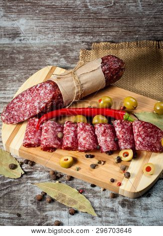 Italian Salami With Olives And Spices On Wooden Background