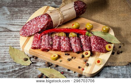 Italian Salami With Olives And Spices On Wooden Background