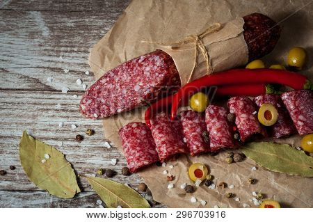 Italian Salami With Olives And Spices On Wooden Background