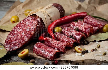 Italian Salami With Olives And Spices On Wooden Background