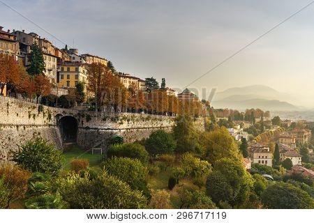 View Of Bergamo City With Sant Andrea Platform Of Venetian Walls At Morning. Italy