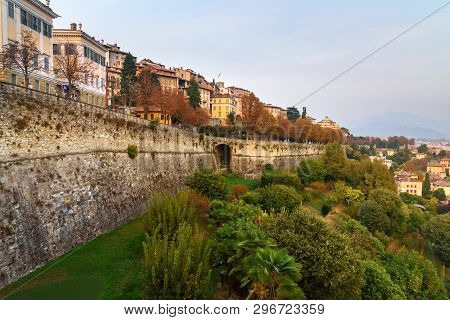 View Of Bergamo City With Sant Andrea Platform Of Venetian Walls In Evening. Italy