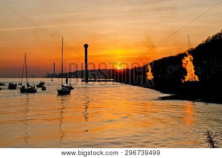 Easter Fire In The Sunset, In The Background The Lighthouse Of Blankenese (hamburg, Germany). Easter