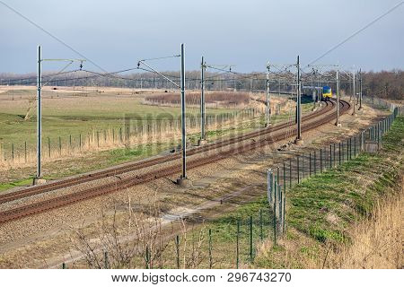 Dutch Railway With Approaching Express Train Through National Park Oostvaardersplassen Between Lelys
