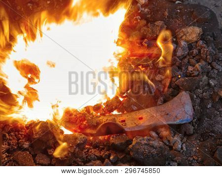 Red Fire Blazes Inside Of Coal Forge.  Blacksmith Traditional Works With Hot Metal  To Form Horse Sh