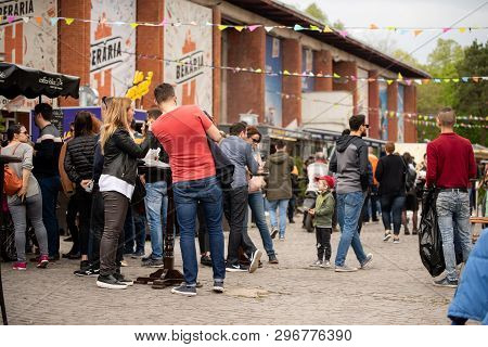 Bucharest, Romania: 21.04.2019 - Street Food Truck Festival - People Sitting And Eating At A Table A