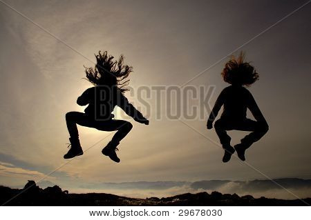 Jumping girls having fun at the sunset
