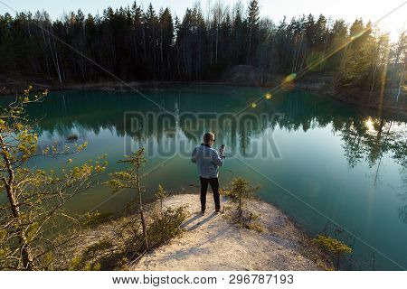 Young Man Take Travel Photos - Beautiful Turquoise Lake In Latvia - Meditirenian Style Colors In Bal