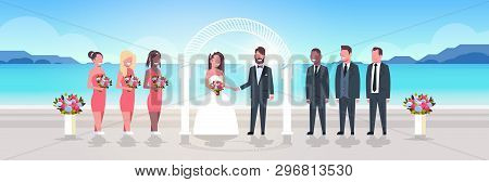 Just Married Bride And Groom With Bridesmaids Groomsmen Standing Together On Sea Beach Near Arch Wed