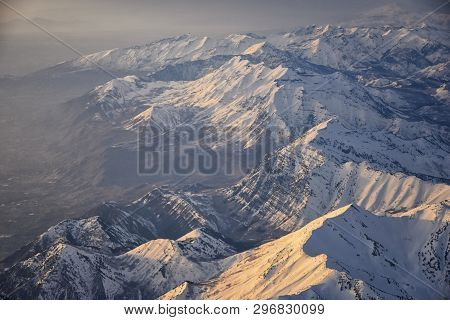 Aerial View From Airplane Of The Wasatch Front Rocky Mountain Range With Snow Capped Peaks In Winter