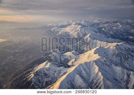 Aerial View From Airplane Of The Wasatch Front Rocky Mountain Range With Snow Capped Peaks In Winter