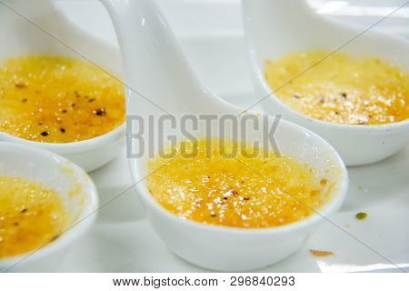 A Cream Brûlée In A White Spoon