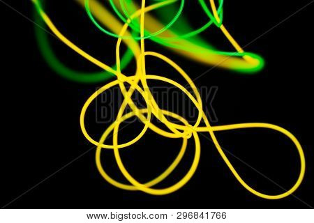 Yellow Neon And Green Neon Abstract. Neon Lines. Isolated On Black Background.
