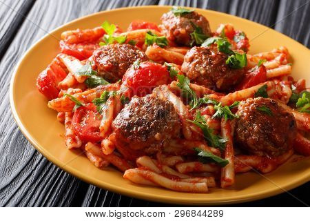 Meatballs With A Side Dish Of Pasta Casarecce In Tomato Sauce Close-up On A Plate. Horizontal