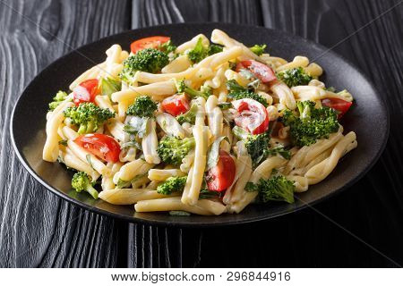 Portion Of Casarecce Pasta With Vegetables, Herbs, Seasoned With Creamy Cheese Sauce Close-up On A P