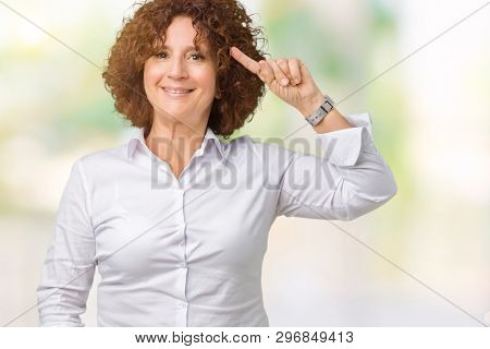 Beautiful middle ager senior businees woman over isolated background Smiling pointing to head with one finger, great idea or thought, good memory