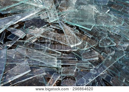 A Pile Of Different Sharp Pieces Of Broken Glass Lying On The Ground. Pieces Of Glass Of Different S