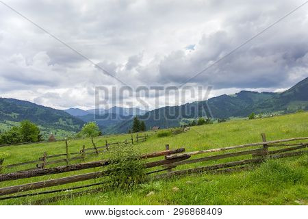 Mountain Slope With Fenced Hayfields On A Foreground On A Background Of Valley, Distant Mountains Co