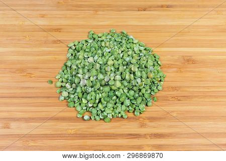 Small Pile Of Raw Green Variety Of The Split Peas On A Bamboo Wooden Surface