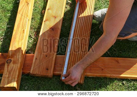 The Worker Measures The Board With A Folding Meter