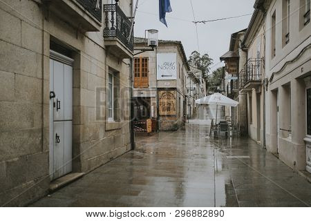 Sarria, Spain - April 6th, 2019: Perspective Of A Popular Street In Sarria Village Center, In A Rain
