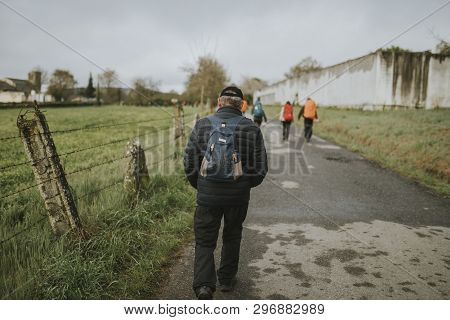 Sarria, Spain - April 6th, 2019: Senior Man Walking As A Pilgrim Of Camino De Santiago Way, Along Fr