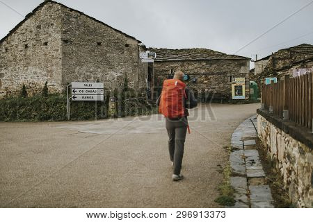 Sarria, Spain - April 7th, 2019: Camino De Santiago Pilgrim Walking With A Backpack Across A Rural P