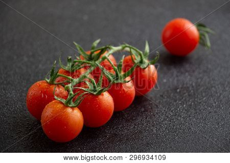 Close-up Of Cherry Tomatoes With Water Drops With Black Background