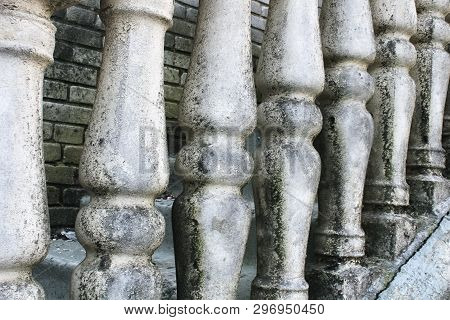 Balusters Made Of Stone On The Old Historic Staircase. Ruins Of Vintage Balusters. Gray, Weathered S