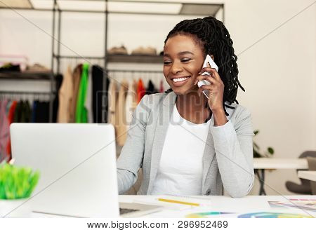 Communication With Suppliers. Woman Tailor Talking On Phone In Workshop With Clothes
