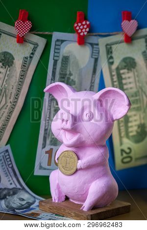 Pink Pig Holding Hryvna Coin. Pig With Hryvna Coin Against The Background Us Dollars Background. Uah