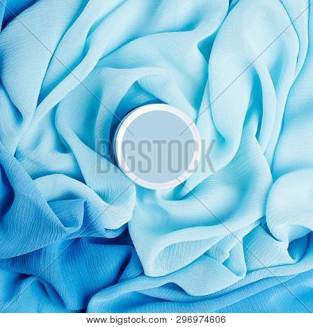 Beauty Cream Box Over Turquoise Vapory And Wavy Cloth Background