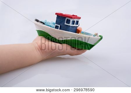 Little Colorful Model Boat In Hand On White Background