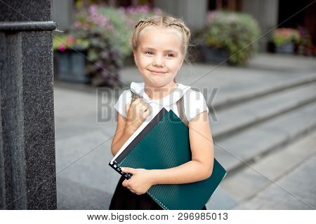 Happy Little Schoolgirl With Book Going Back To School Outdoor.