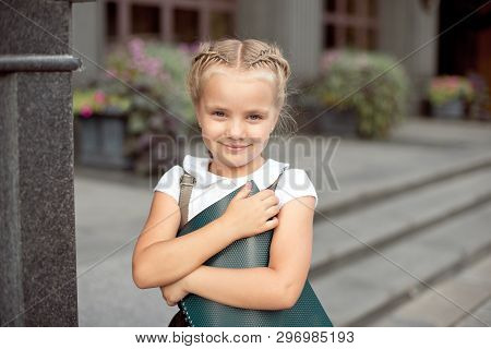 Happy Little Schoolgirl With Book Going Back To School Outdoor.