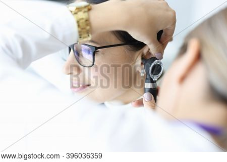 Otolaryngologist Doctor Examining Patients Ear With Otoscope In Clinic. Diagnosis Of Otitis Media Co
