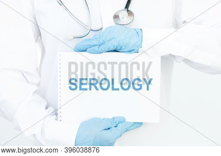 Doctor Holds A Card With The Name Of The Diagnosis Serology. Medical Concept.