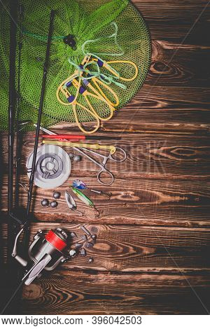 Fishing Tackle On A Wooden Background. Studio Photo With Vignetting.