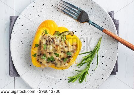 Stuffed Sweet Peppers With Rice Mushrooms And Cheese With Herbs. Baked Halves Of Yellow Peppers With