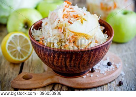 Homemade Sauerkraut With Green Apple And Carrot In A Clay Bowl