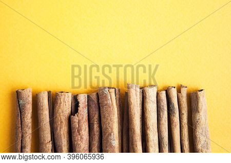 Cinnamon Sticks On The Yellow Background With Copy Space For Your Text