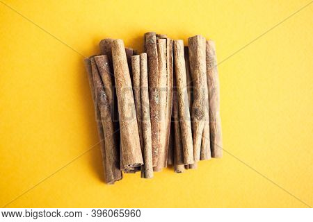 Cinnamon Sticks On The Yellow Background With Copy Space For Your Text